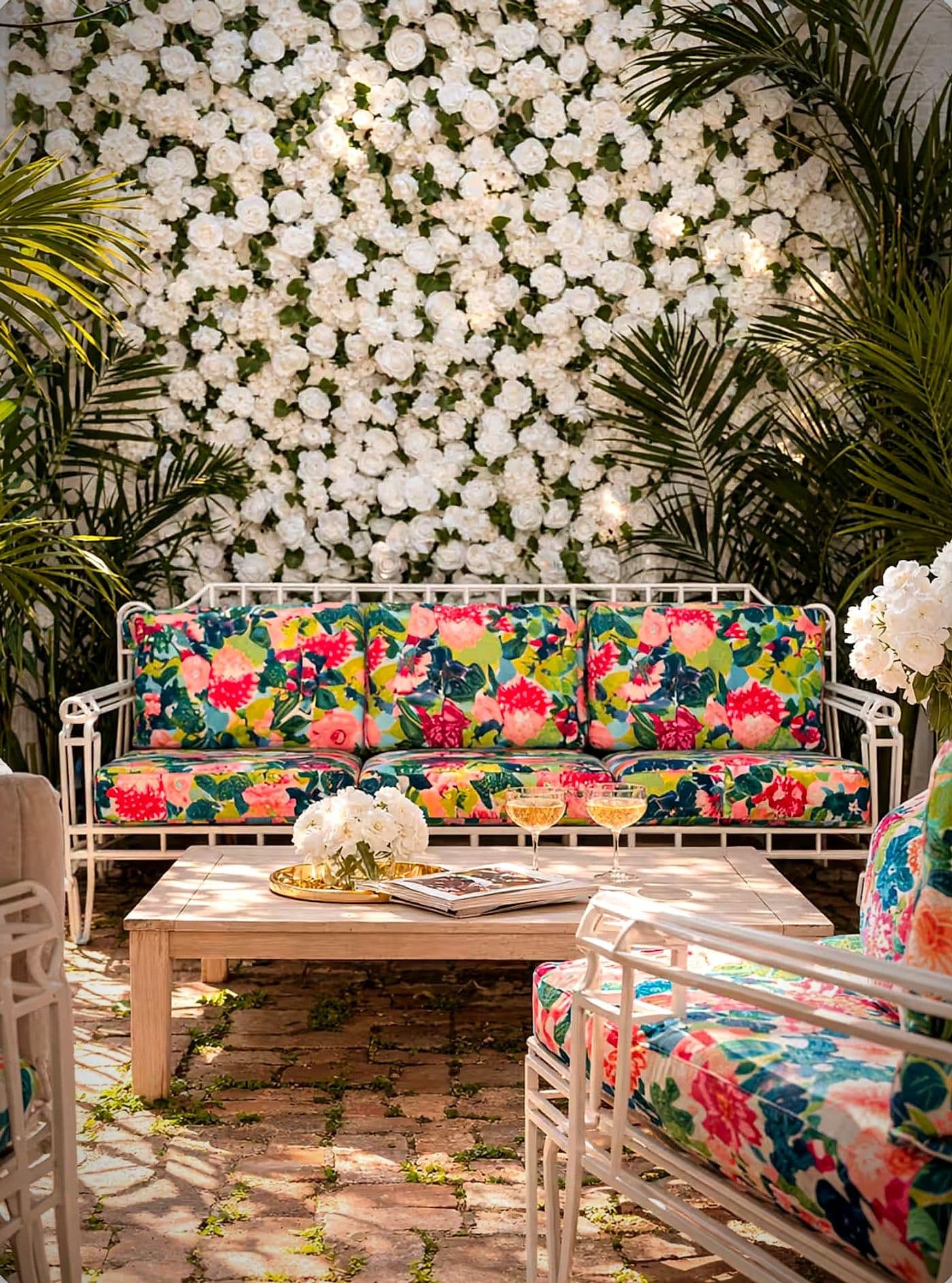 The courtyard at Maison St. LaFleur, with a flower wall and lounge seating