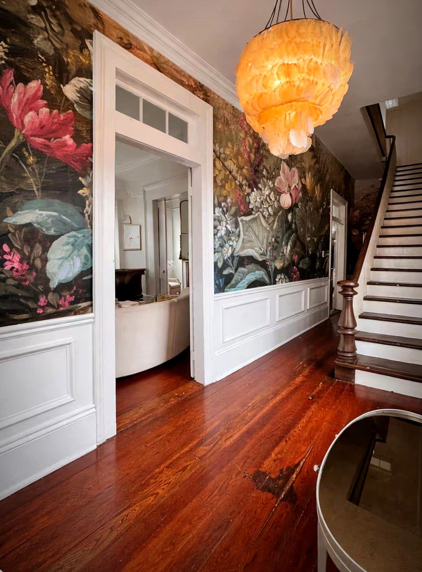 Hand-painted floral mural wallpaper in the entry hall at Maison St. LaFleur, with the original staircase