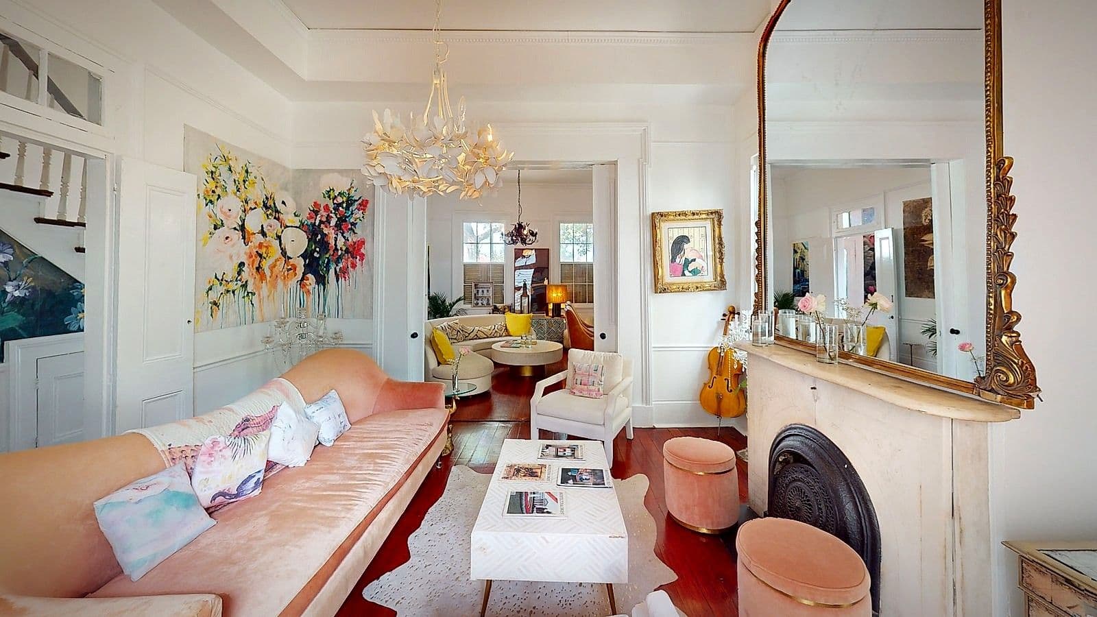 The double parlor at Maison St. LaFleur, with blush velvet seating and an antique gold mirror